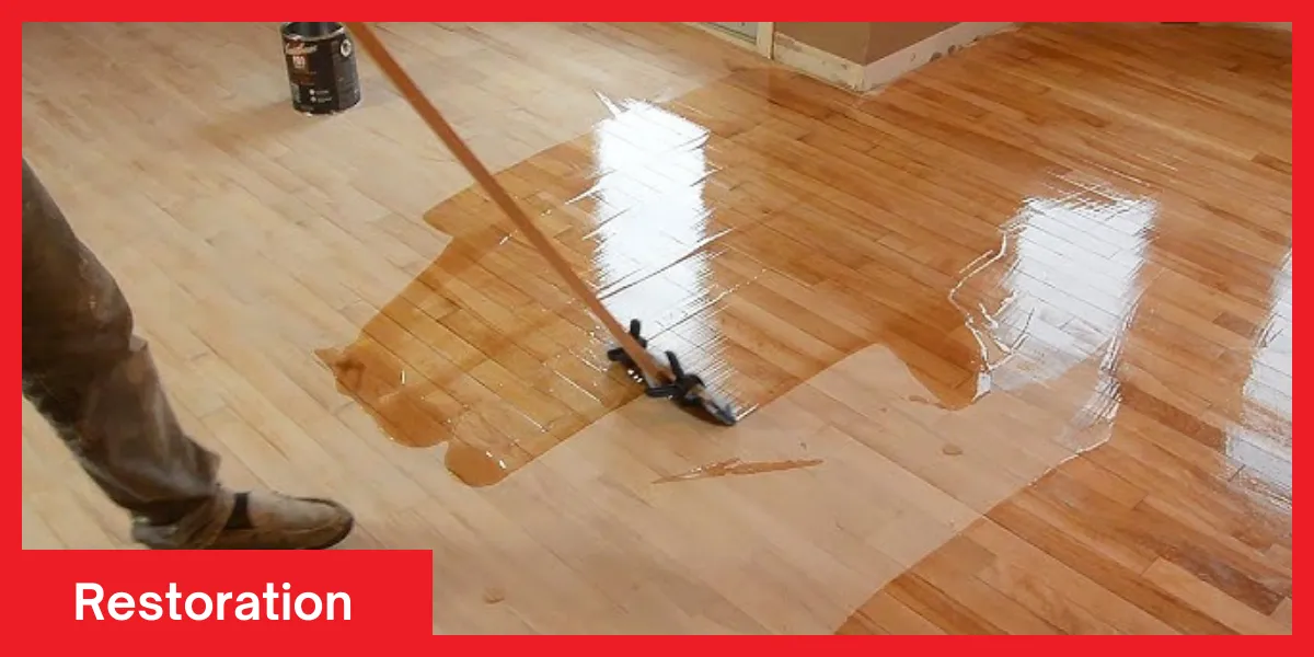 Restoration Person applying a glossy wood finish during a floor restoration process