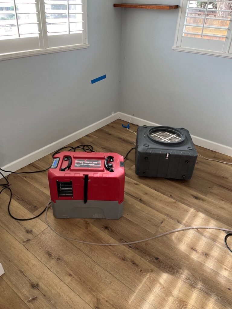 Air mover drying a bedroom wall in a Ventura County home