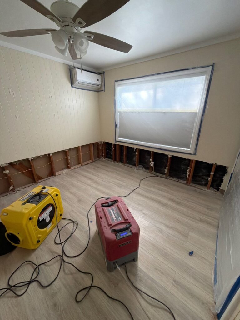 Baseboards removed and air movers running in a Ventura County room
