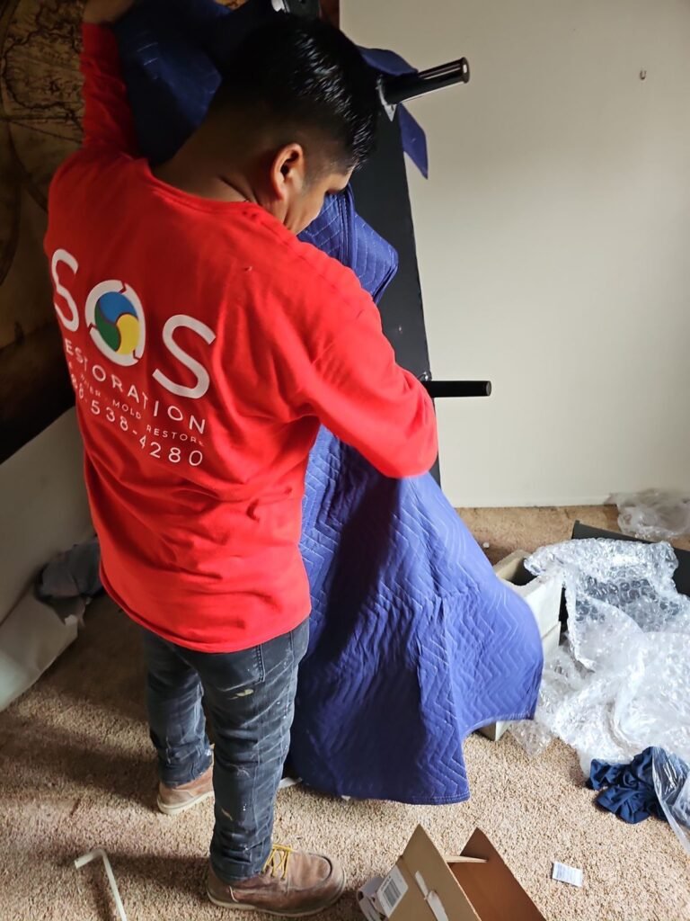 An SOS technician wrapping a mattress in protective plastic in Ventura County