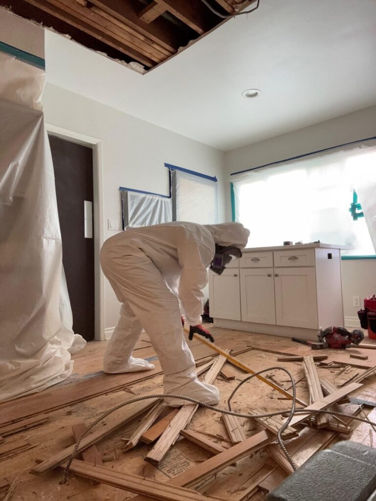 A technician pulling floor battens in a kitchen with the ceiling opened in Ventura County
